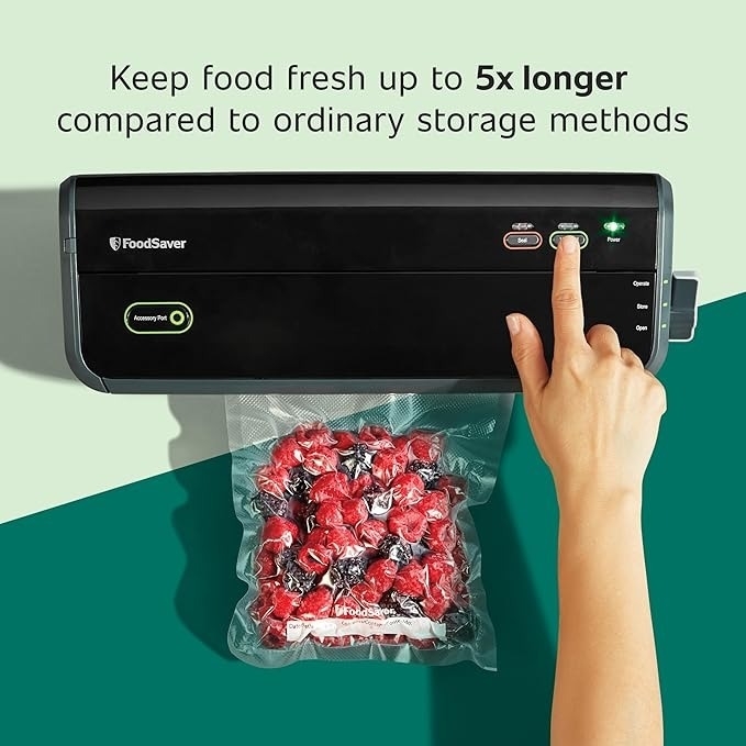 Hand using a vacuum sealer to preserve a bag of red candies with text: &quot;Keep food fresh up to 5x longer compared to ordinary storage methods.&quot;