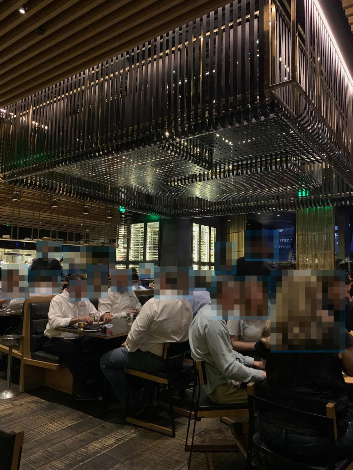 People dining in a modern, upscale restaurant with a striking, metal ceiling design