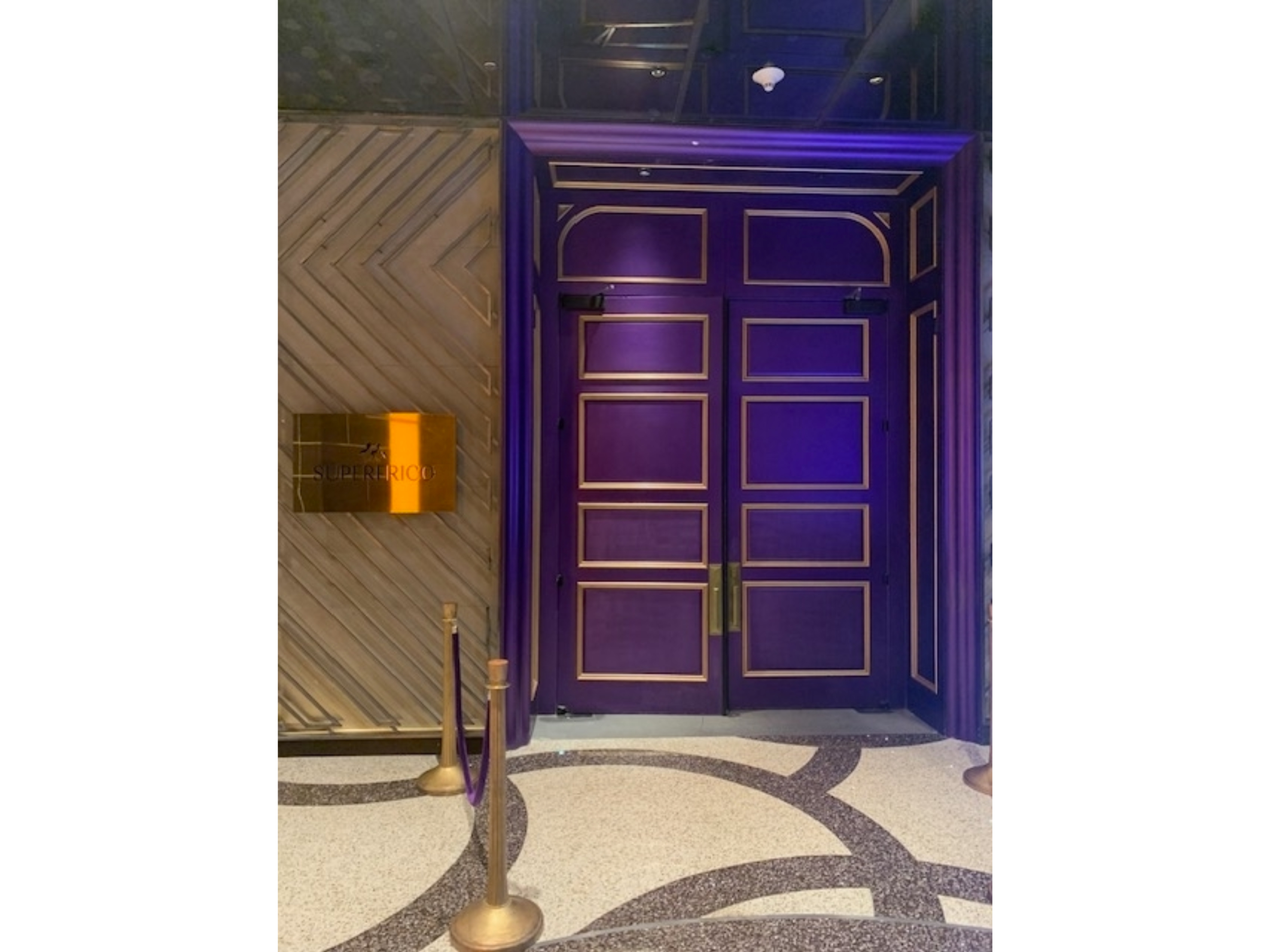 Entrance to the Superfrico restaurant with double doors and a brass plaque on a patterned floor