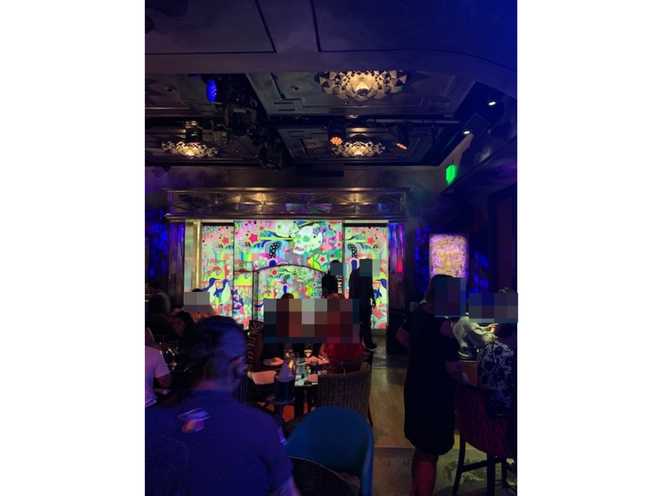 People dining in a lively, artistic restaurant with colorful, abstract wall art