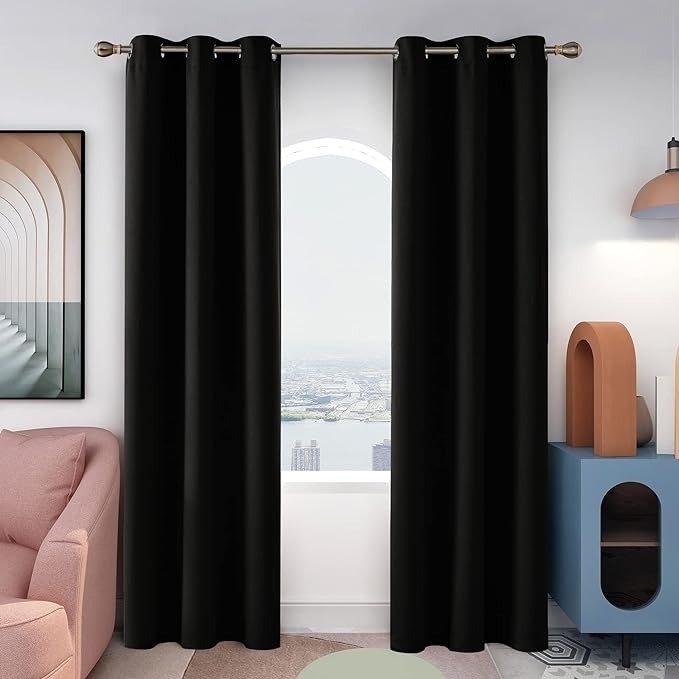 Room with modern decor featuring black curtains on a window, a pink sofa, and geometric shelves