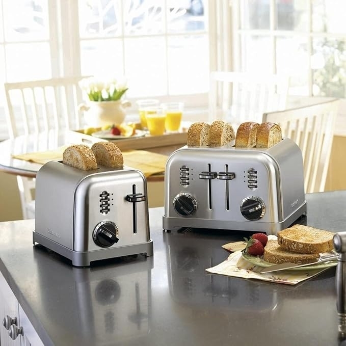 Two stainless steel toasters with multiple settings; toast is ready on a kitchen counter, implying a focus on home appliances