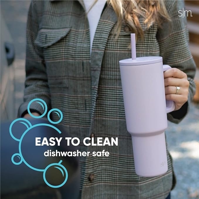 Person holding large reusable cup with straw. Text reads, &quot;Easy to clean, dishwasher safe.&quot; Cup designed for convenience