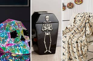 A prismatic skull decoration next to a black coffin-shaped box with a skeleton design and a chair draped with a plaid blanket with bat patterns