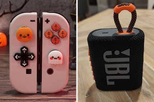 Nintendo Switch controllers with cute Halloween-themed buttons and a JBL portable speaker on a table