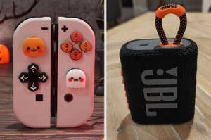 Nintendo Switch controllers with cute Halloween-themed buttons and a JBL portable speaker on a table