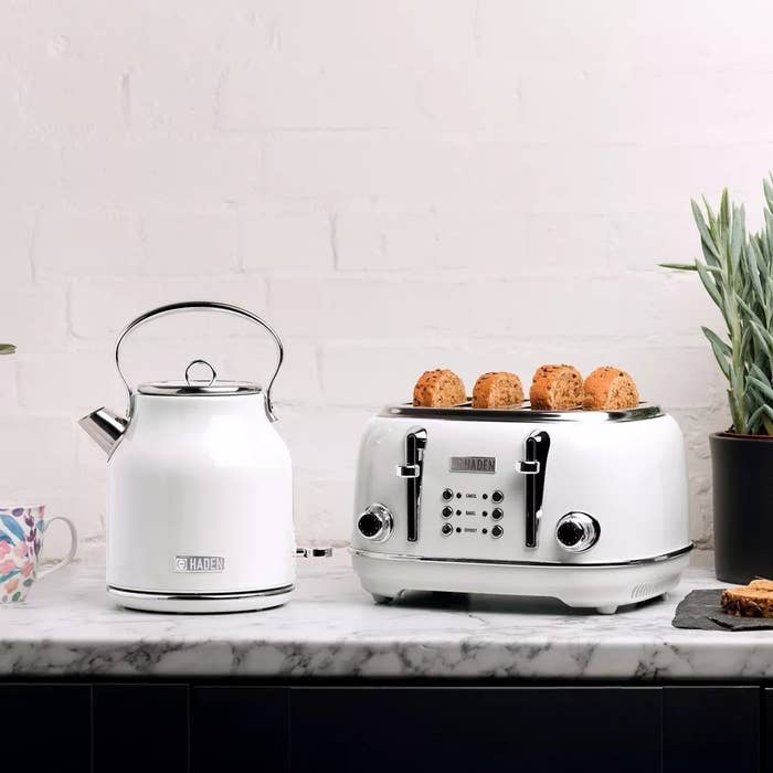 Electric kettle and toaster on a kitchen counter with bread slices and a mug, showcasing modern kitchen appliances