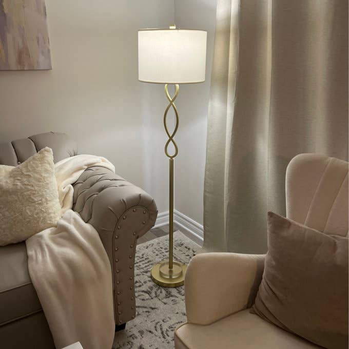 Cozy surviving  country   country   with a modern   level  lamp, a tufted sofa draped with a blanket, and an armchair with pillows
