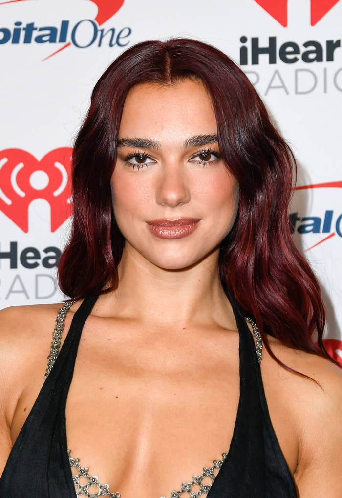A person at the iHeartRadio event wearing a stylish dress with metallic details