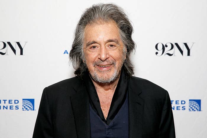 I don&#x27;t know who this person is. An older man with long hair smiles, wearing a black blazer over a dark shirt at a public event