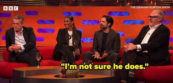 I don&#x27;t know who these people are, but they are sitting on a talk show sofa, dressed in formal and semi-formal attire, engaged in conversation