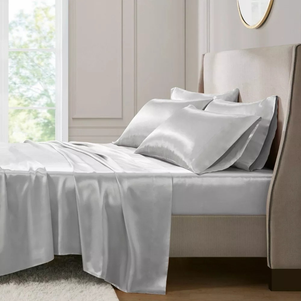 Luxurious satin bed set with pillowcases and a comforter on a neatly made bed in a stylish bedroom