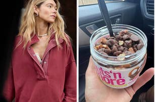 Model wears an oversized sweater while holding a jar of Nuts 'n More protein peanut spread mixed with chocolate chips and pretzel pieces