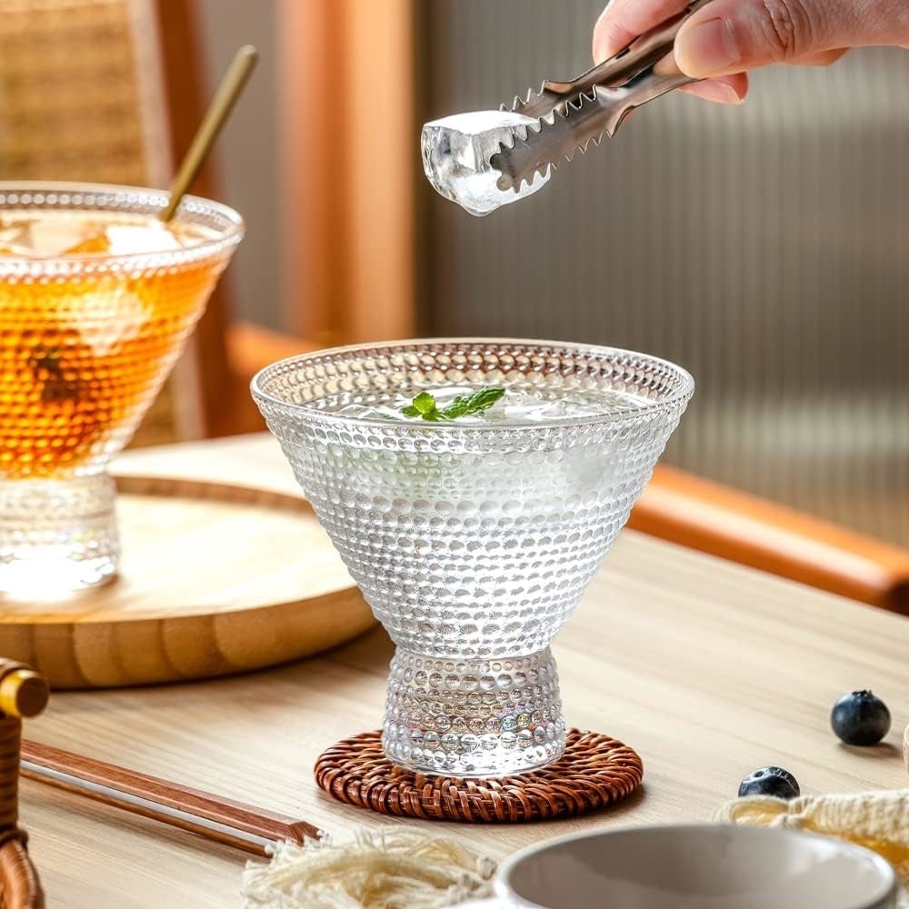 Person utilizing tongs to spot  crystal  successful  a textured solid  connected  a table; different  portion  with crystal  and garnish is nearby. Various tiny  items and nutrient  are visible
