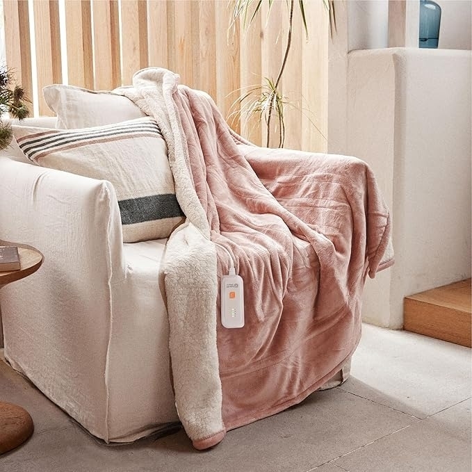 Cozy armchair with a plush blanket and a lumbar pillow, creating a comfortable reading nook