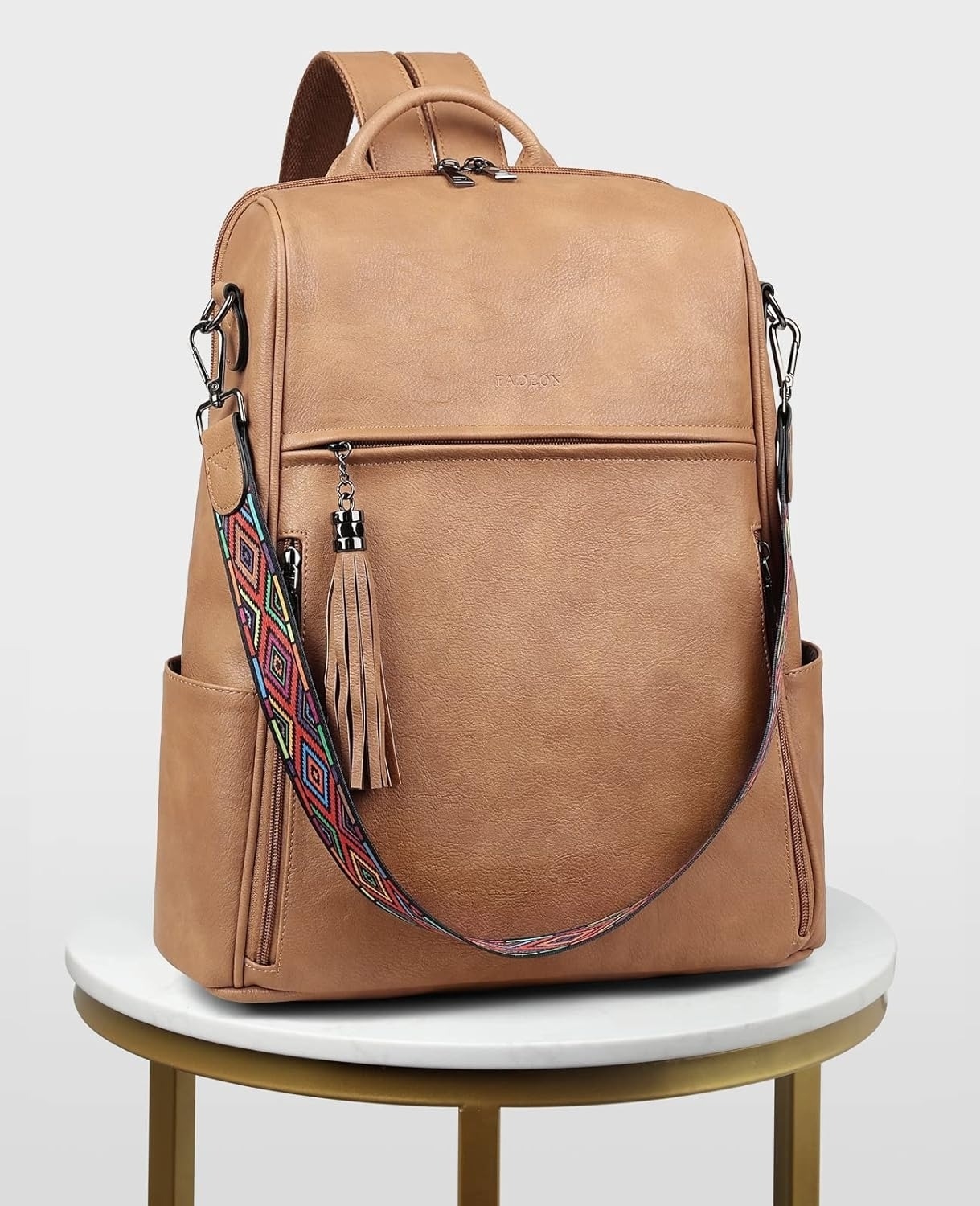 Stylish leather backpack with a geometric strap and tassel, perfect for carrying essentials while shopping