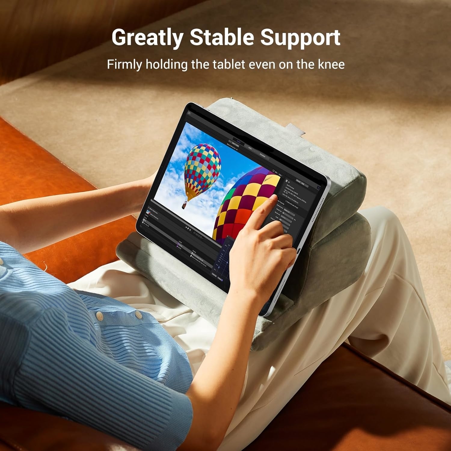 Person using a tablet on a cushion stand, displaying a hot air balloon image, with the text &quot;Greatly Stable Support&quot; above