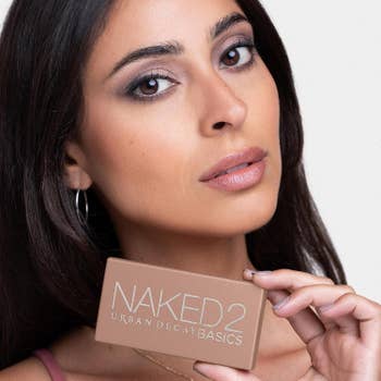 Model poses with Urban Decay Naked2 Basics eyeshadow palette