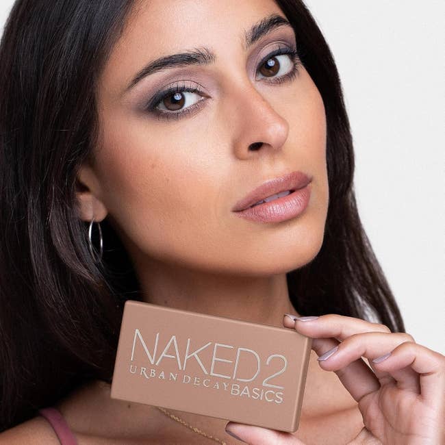 Model poses with Urban Decay Naked2 Basics eyeshadow palette
