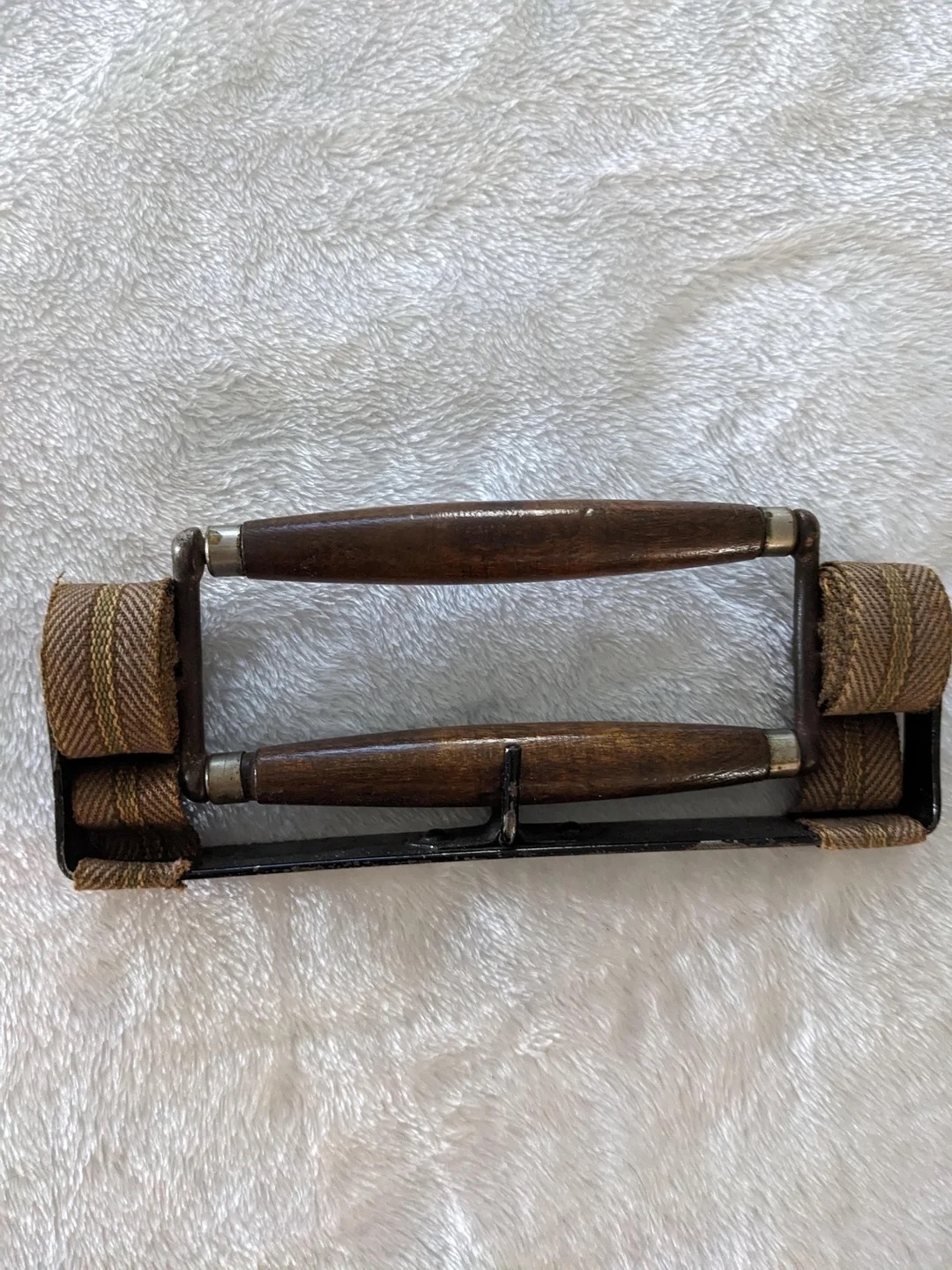 A pair of wooden handles and with woven straps design on a textured background