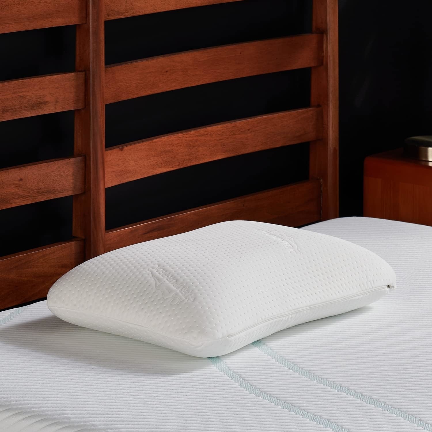 Memory foam pillow on a bed with a wooden headboard, featured in a shopping article