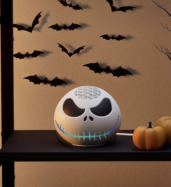 Halloween-themed talker with Jack Skellington plan connected a shelf, surrounded by bat decorations and a tiny pumpkin