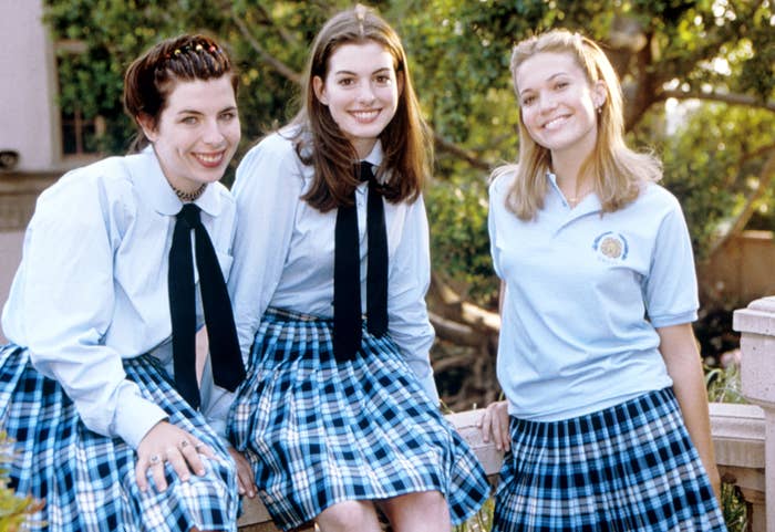 Heather Matarazzo, Anne Hathaway, and Mandy Moore in school outfits smile for a picture on the set of Princess Diaries