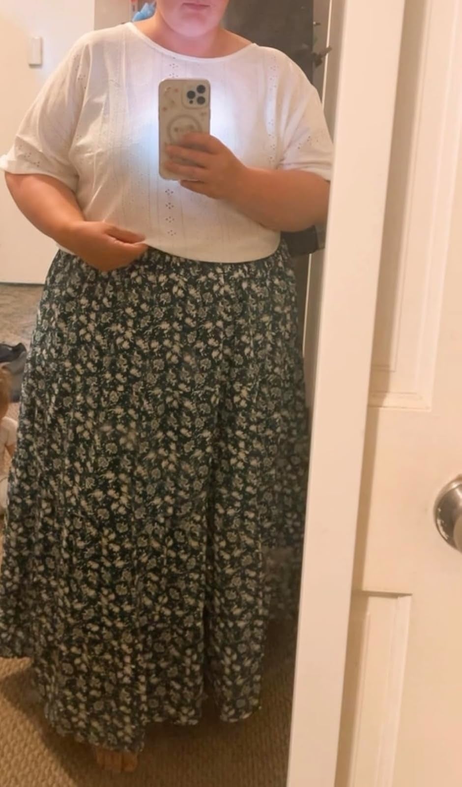 Person taking a reflector  selfie wearing a achromatic  apical  and a long, achromatic  floral skirt
