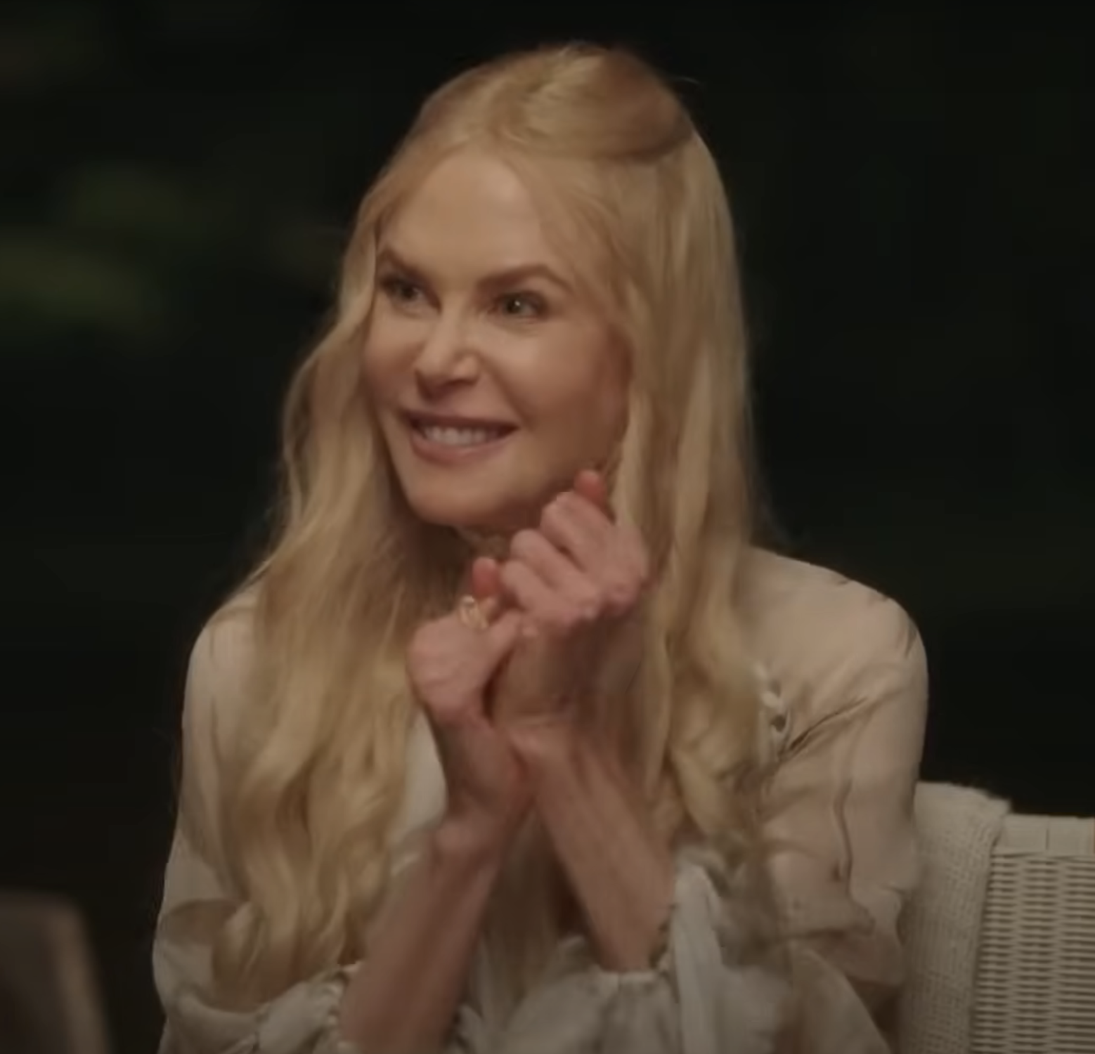 I don't know who is in the image. The person is smiling with long hair and wearing a light, sheer blouse