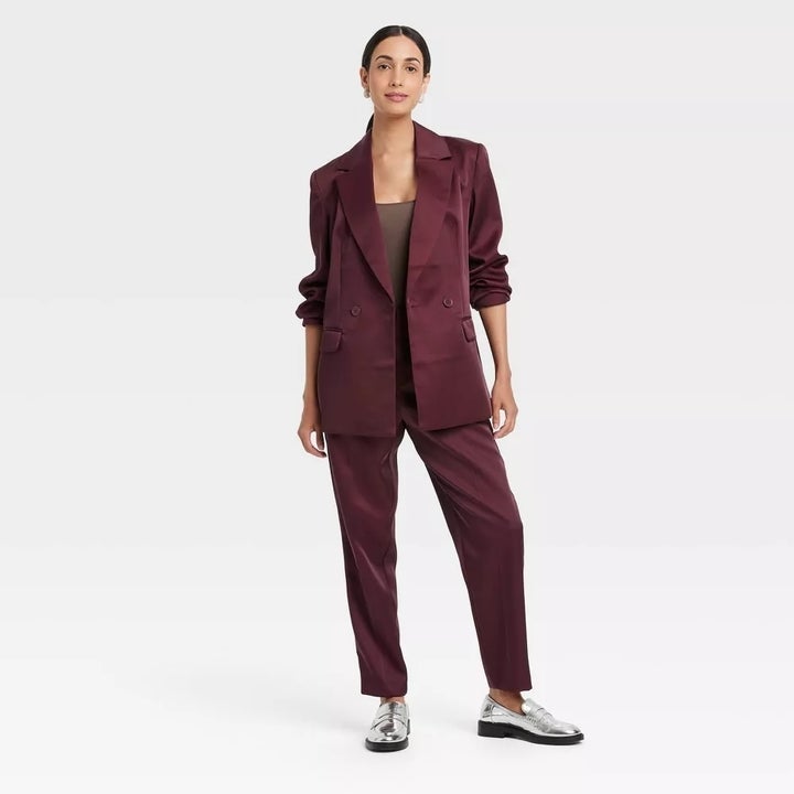 A model in a stylish oversized suit stands confidently, modeling for a shopping feature