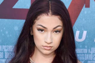 Bhad Bhabie on the red carpet wearing a strapless top and a chain necklace with long wavy hair