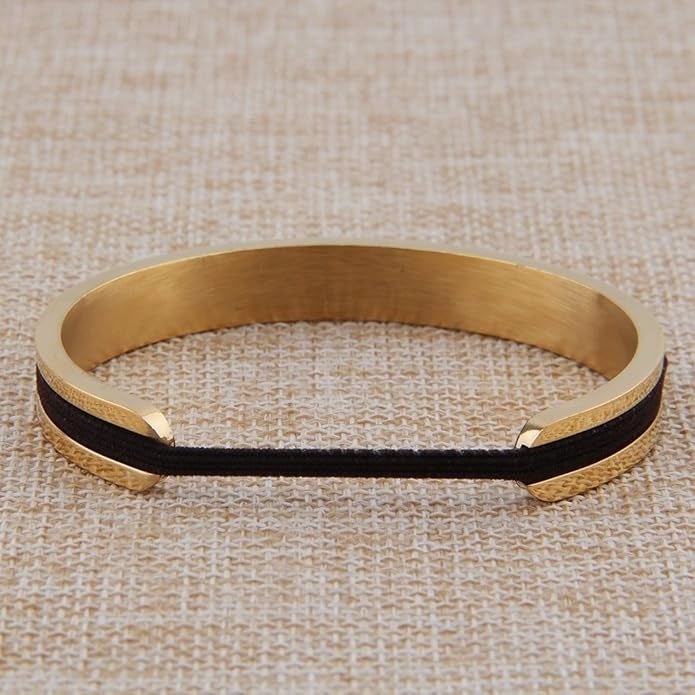 A golden  cuff bracelet with a achromatic  set  crossed  the center