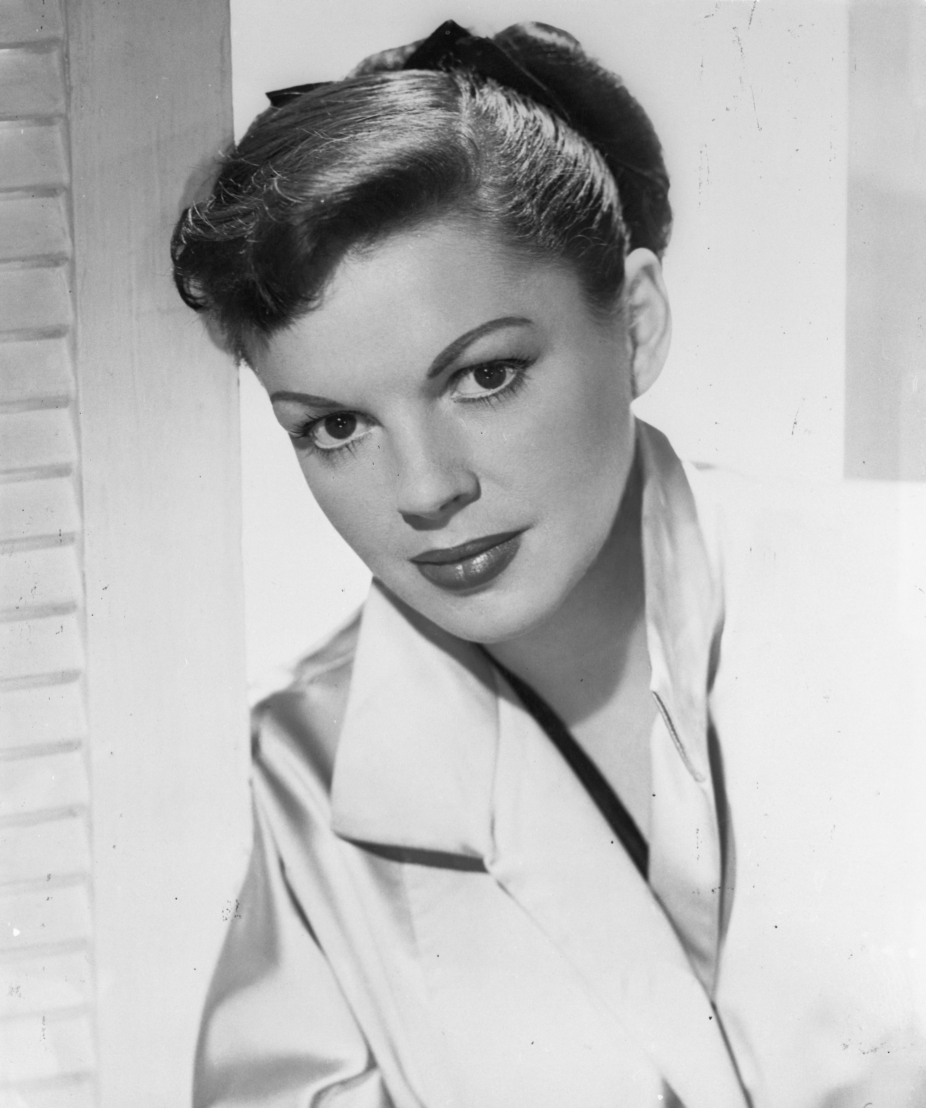 A close-up of Judy Garland wearing a silk shirt with her hair pulled back in a high ponytail