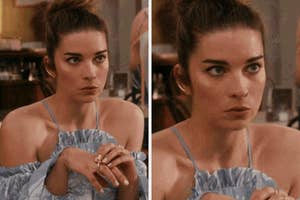 Person at a table, wearing a ruffled strapless dress, with hair in a bun, looking focused or concerned