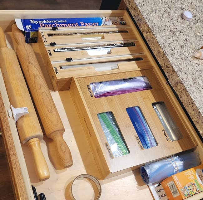 Organized room drawer with parchment paper, foil, wax, and zipper bags successful dispensers, positive rolling pins and tape