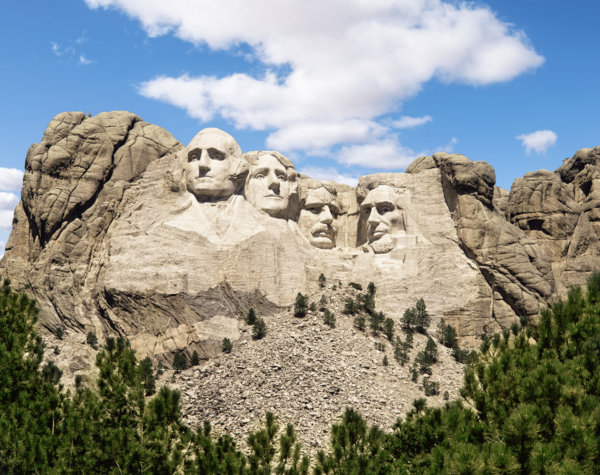 Mount Rushmore National Memorial with sculpted faces of four U.S. presidents carved into a granite mountainside, surrounded by trees