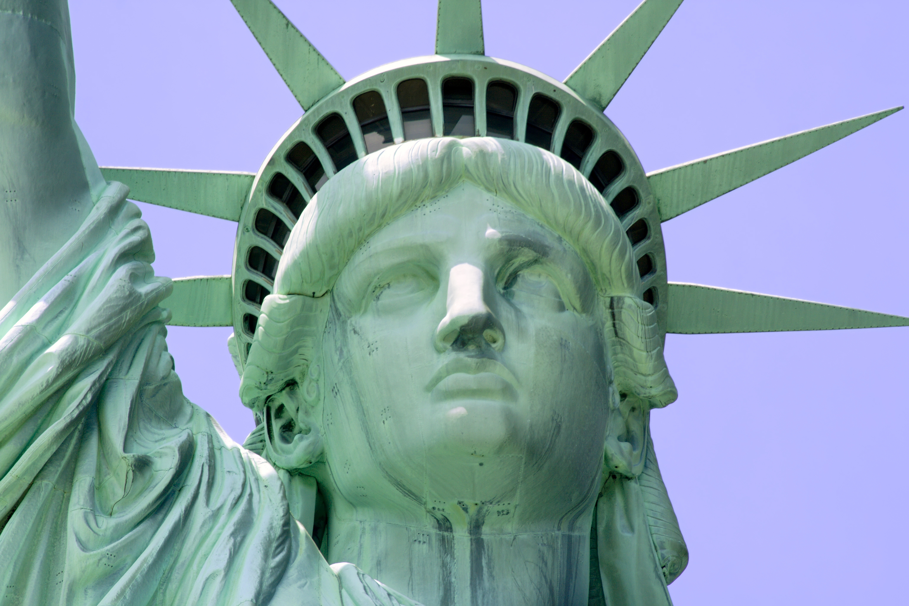 Close-up of the Statue of Liberty&#x27;s face and crown against a clear sky