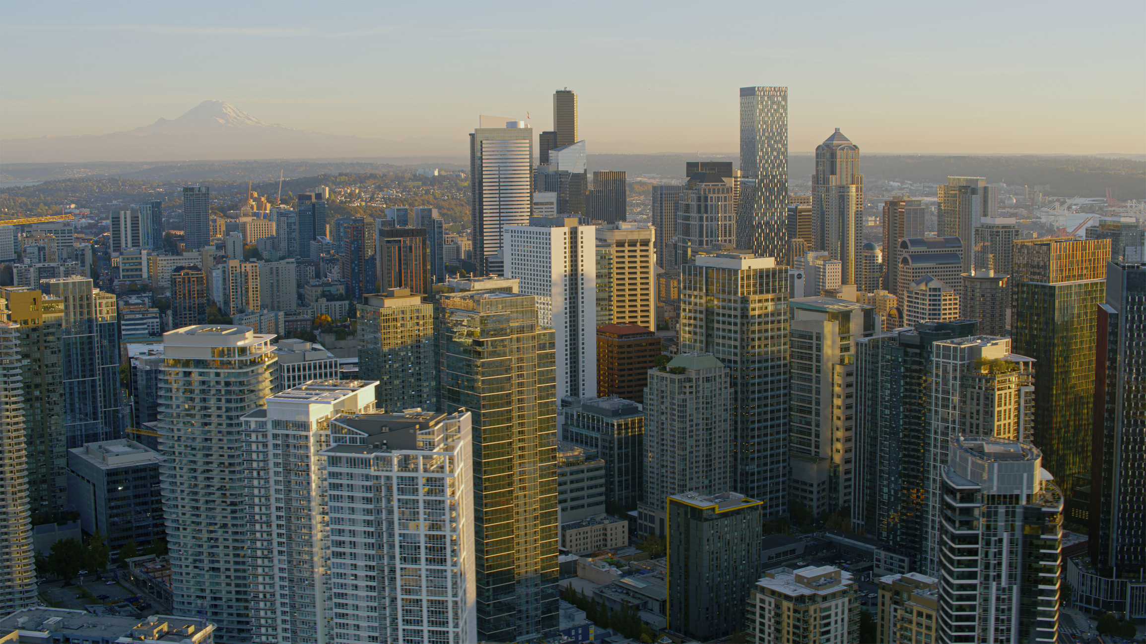 A cityscape view of downtown skyscrapers with a mountain in the distant background