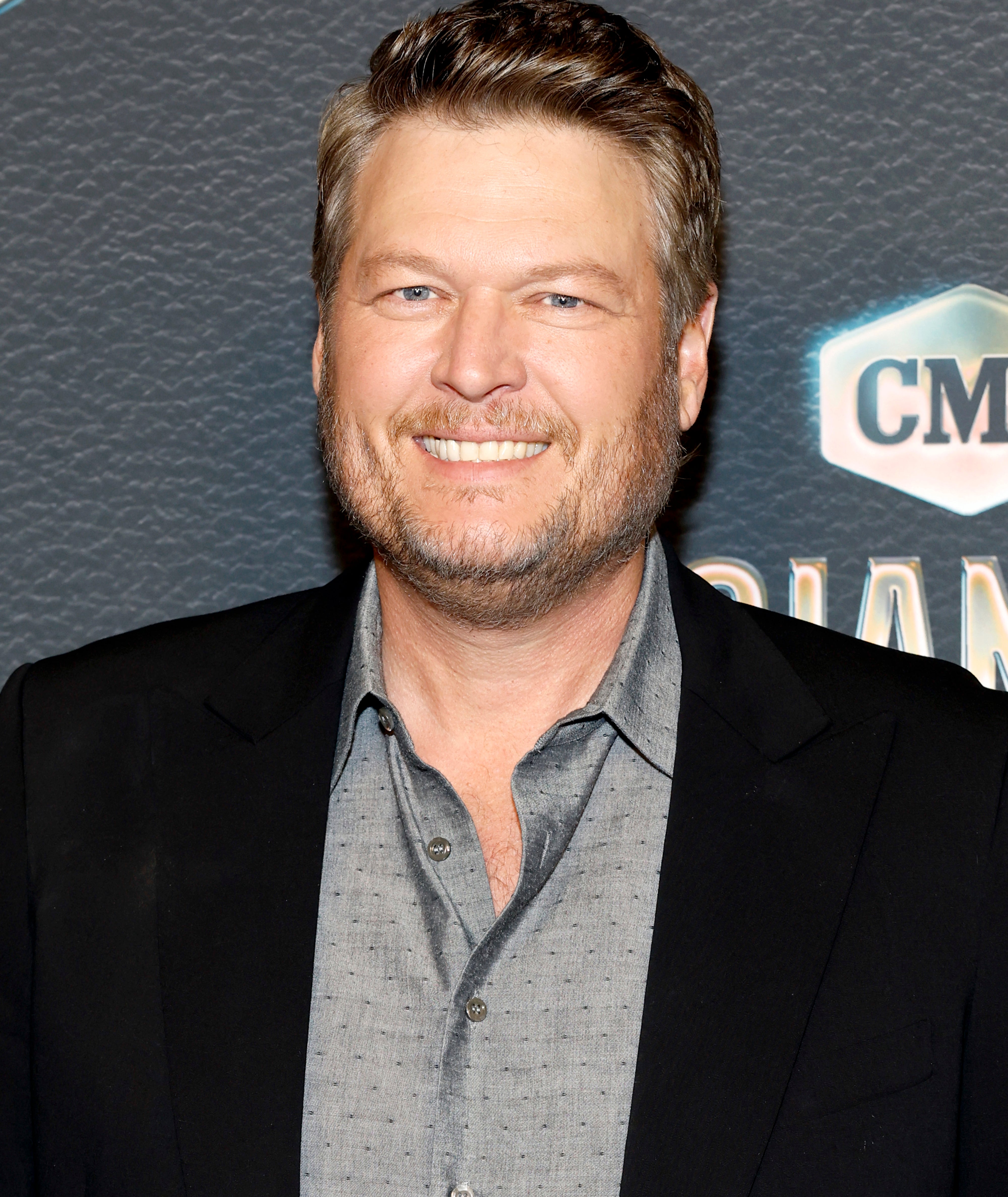 Blake Shelton in a suit with a casual shirt at an event