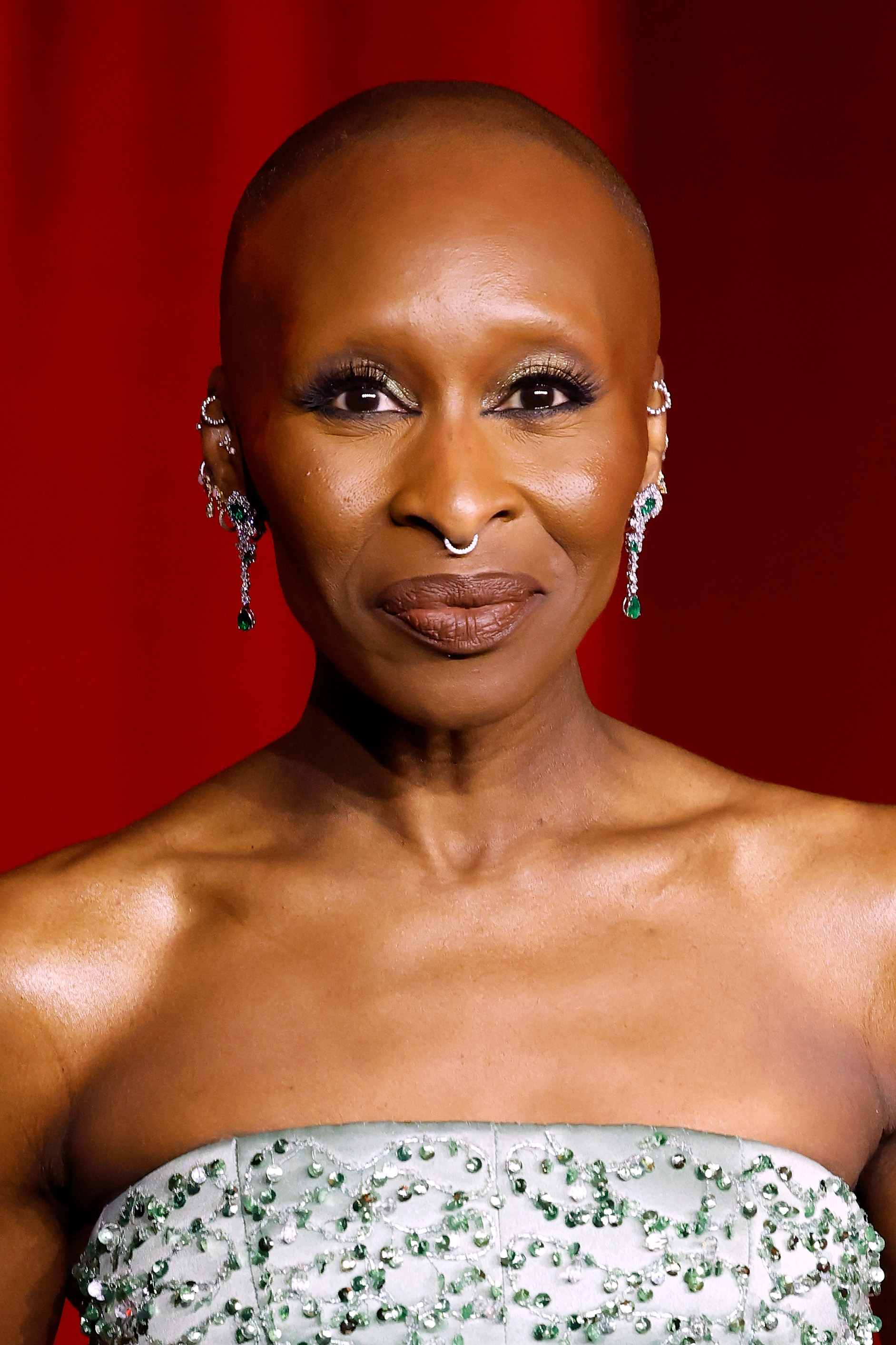 Person wearing strapless textured gown and dangling earrings on a red carpet