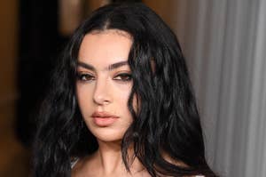 Charli XCX wearing a sleeveless top with metallic embellishments, posing at an event