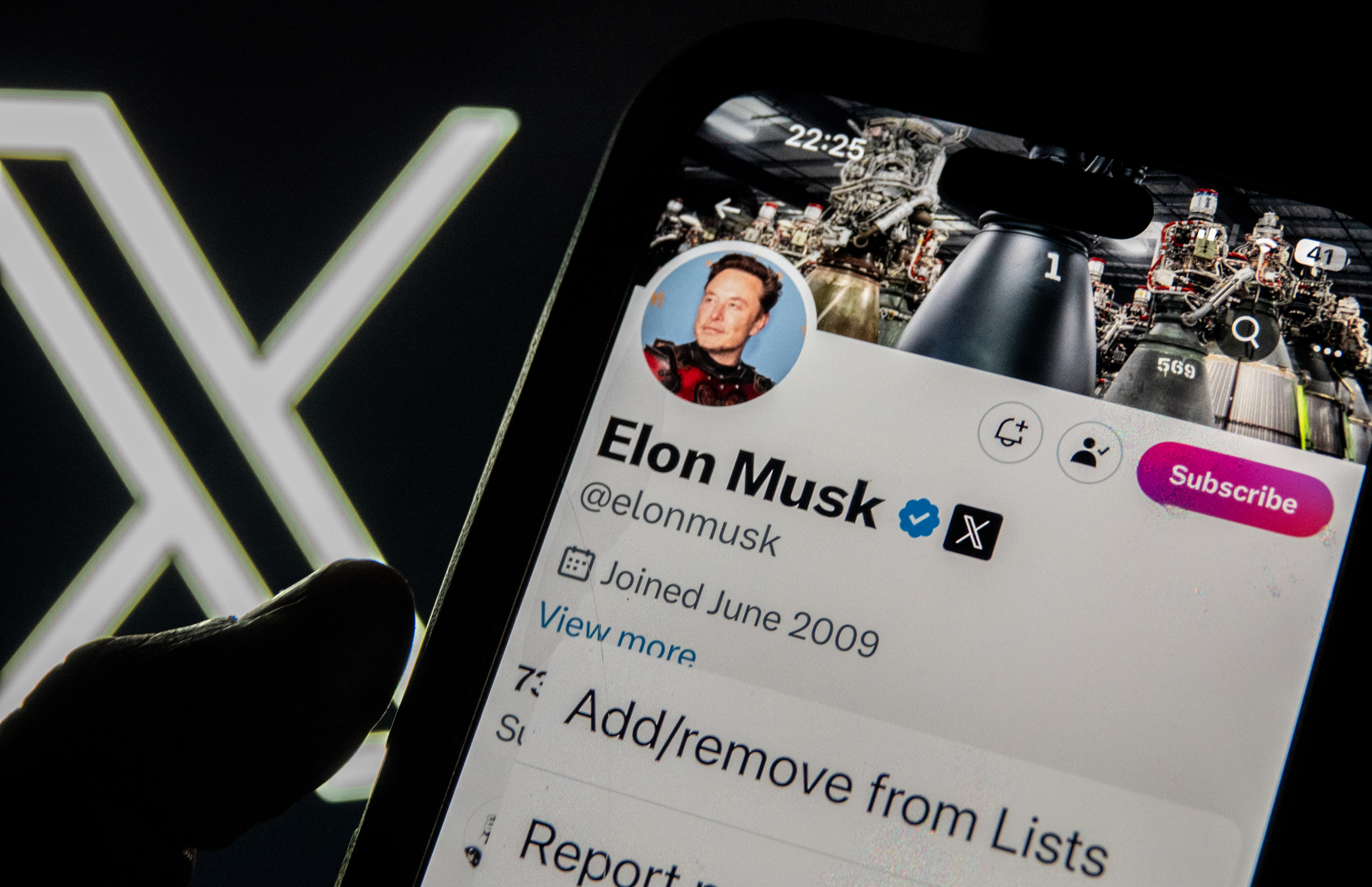 Smartphone screen showing Elon Musk's Twitter profile; user navigates menu options