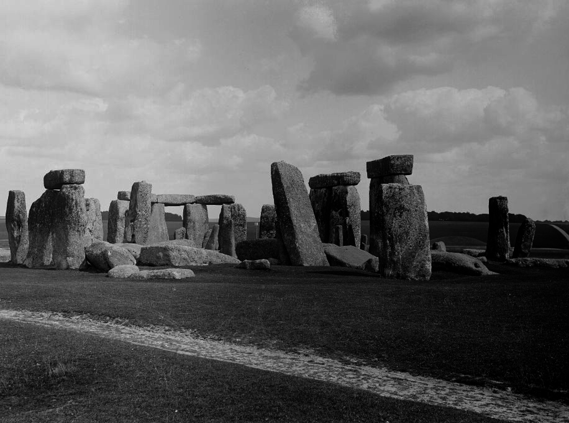 Black and white image of Stonehenge, featuring large ancient stone structures under a cloudy sky