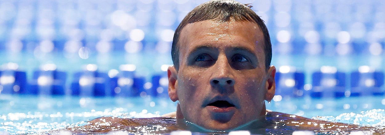 Person swimming in a pool, emerging between lane dividers, with a focused expression