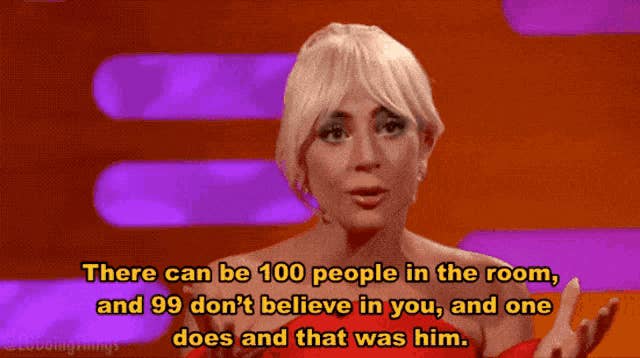 A celebrity wearing an elegant outfit speaks during an interview. Text reads: