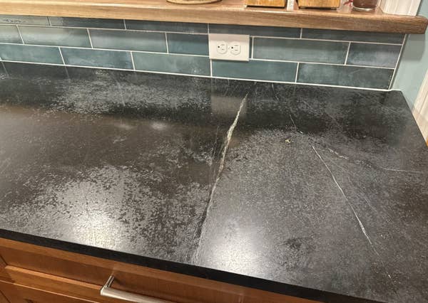 Soapstone countertop with visible seams and variations. Reddit post discusses potential sealing needs and seeks advice on maintenance and care