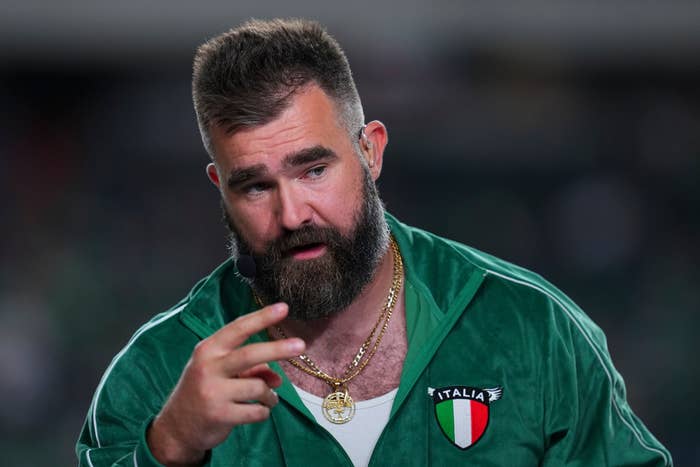 Jason Kelce in a tracksuit with various patches and a chain