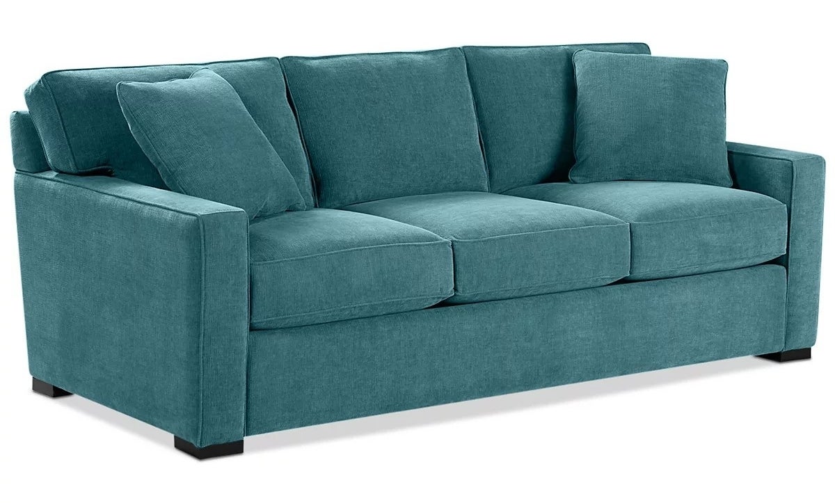 Modern teal sofa with three cushions, rectangular armrests, and a sleek design. Suitable for a contemporary living room or lounge area