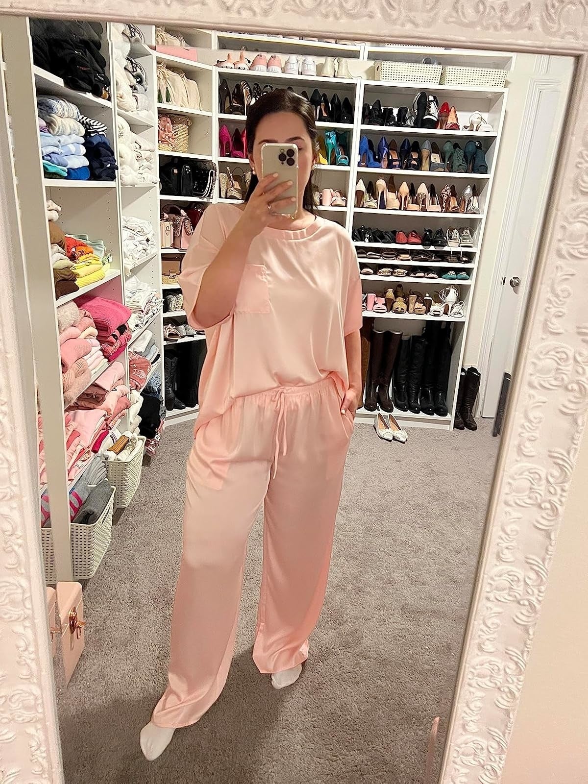 A reviewer taking a reflector  selfie wearing silk pajamas