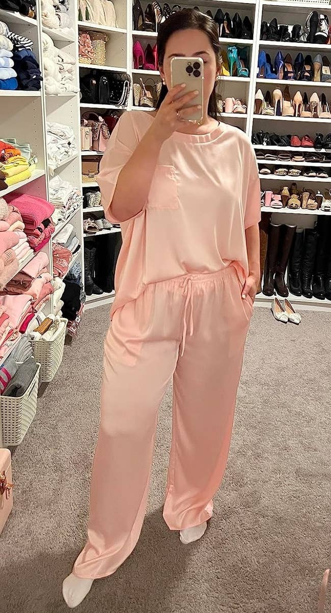A reviewer taking a reflector selfie wearing silk pajamas